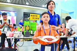 来自中山石岐中心小学的潘志文用自制机器人为妈妈做了一个炒花生米。