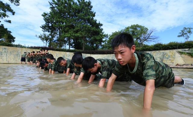 
7月20日，来自不同学校的中小学生在江西新余市一家军事化拓展基地参加“小小特种兵”水中集体训练课程。